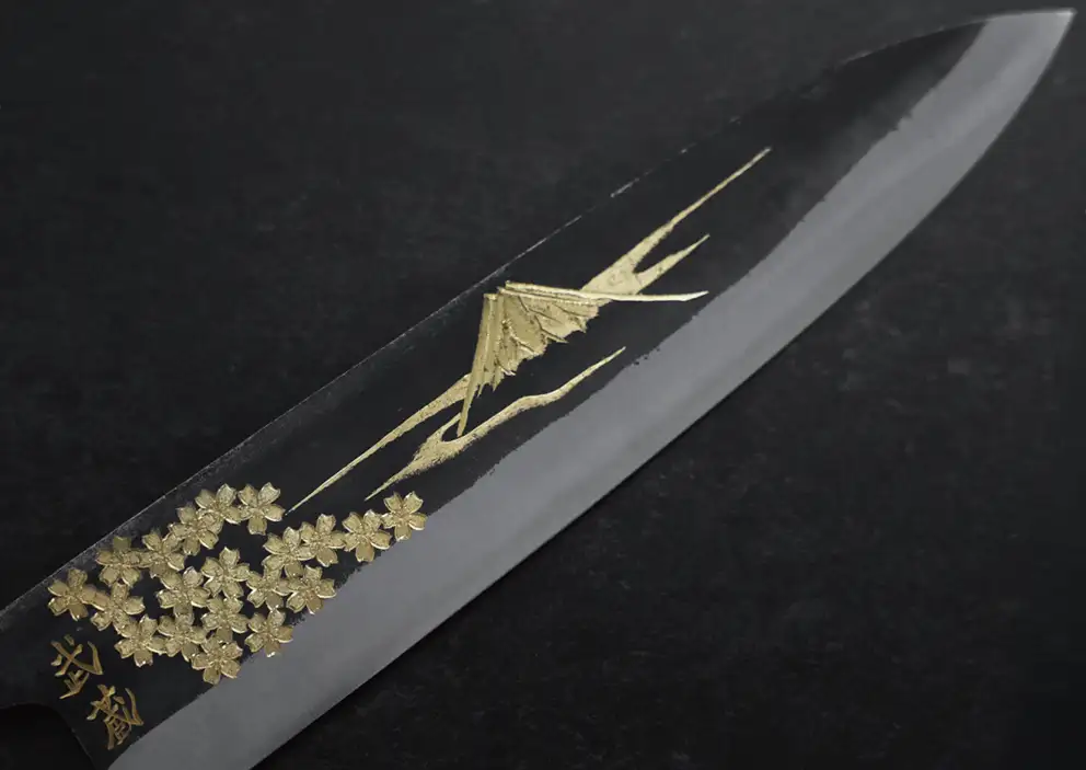 黒打ちの刃に金色で富士山と桜が描かれた和包丁。刃元に「武蔵」の文字。